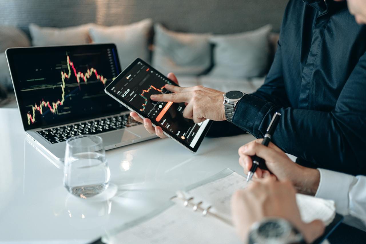 3 Ações para Investir em Inteligência Artificial (IA) em 2024 1 Um computador e um tablet com telas de negociação abertas na mesa.